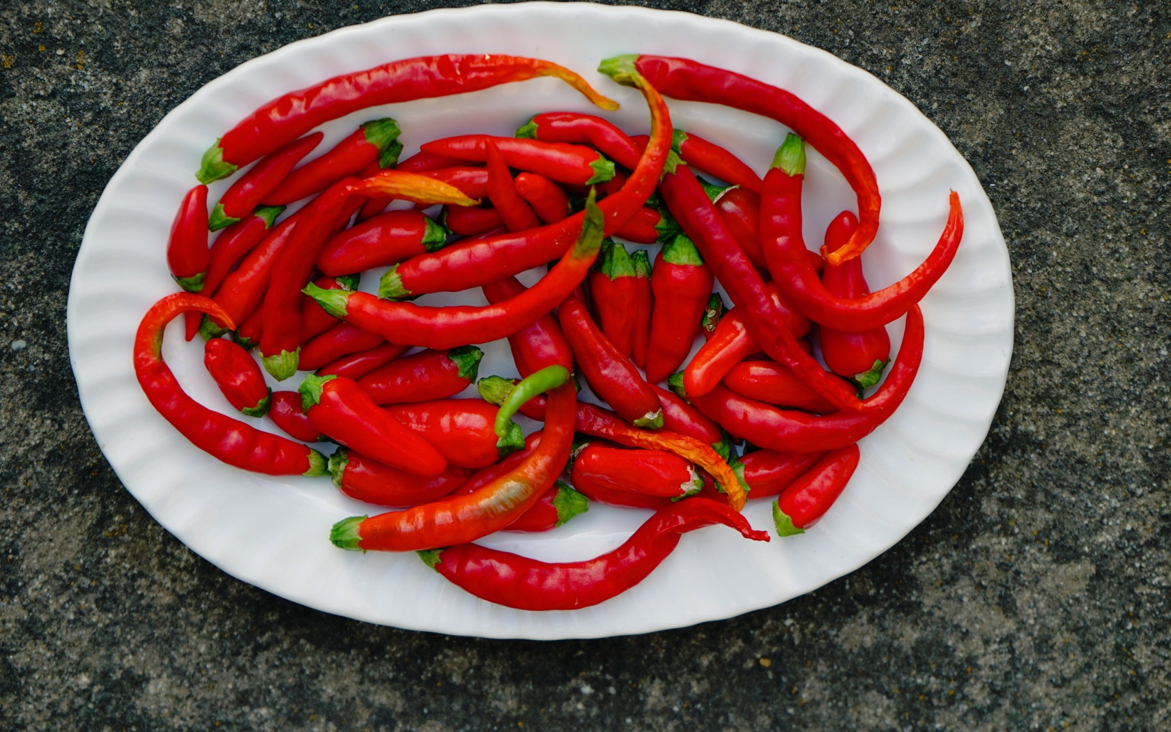 Острый красный перец чили на большой белой тарелке