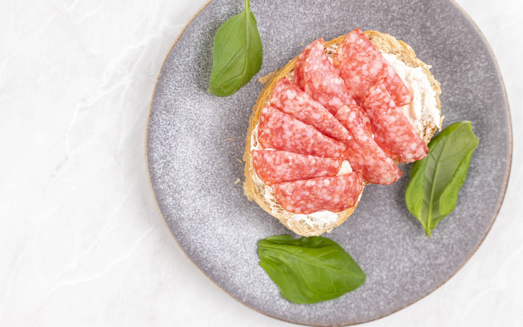 Бутерброд с маслом и колбасой на тарелке