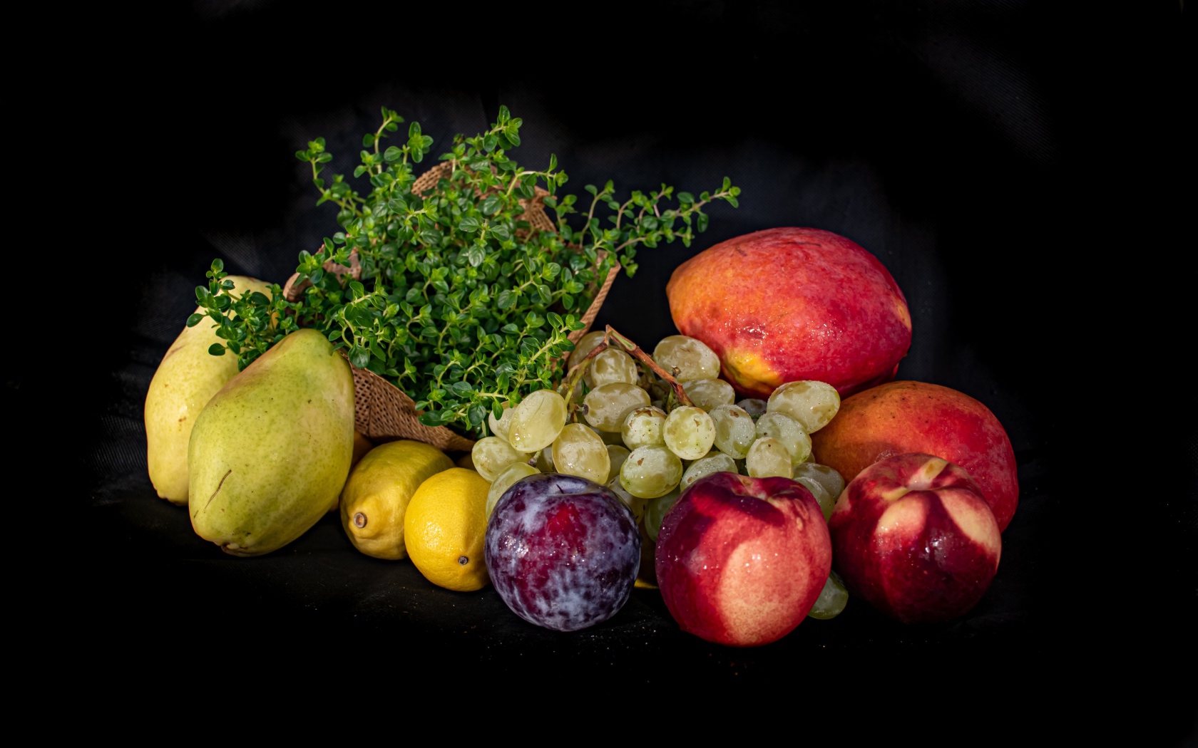 Свежие фрукты с зеленью на черном фоне 
