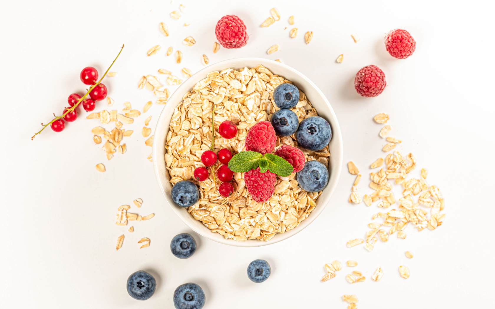 Овсяные хлопья с ягодами черники и малины на белом фоне 