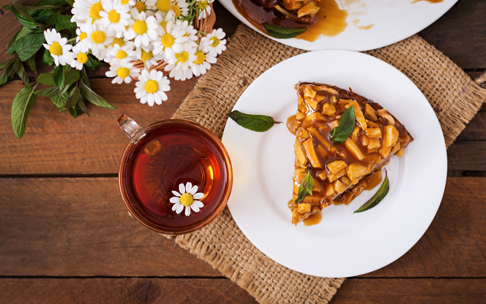 Кружка ромашкового чая на столе с куском пирога