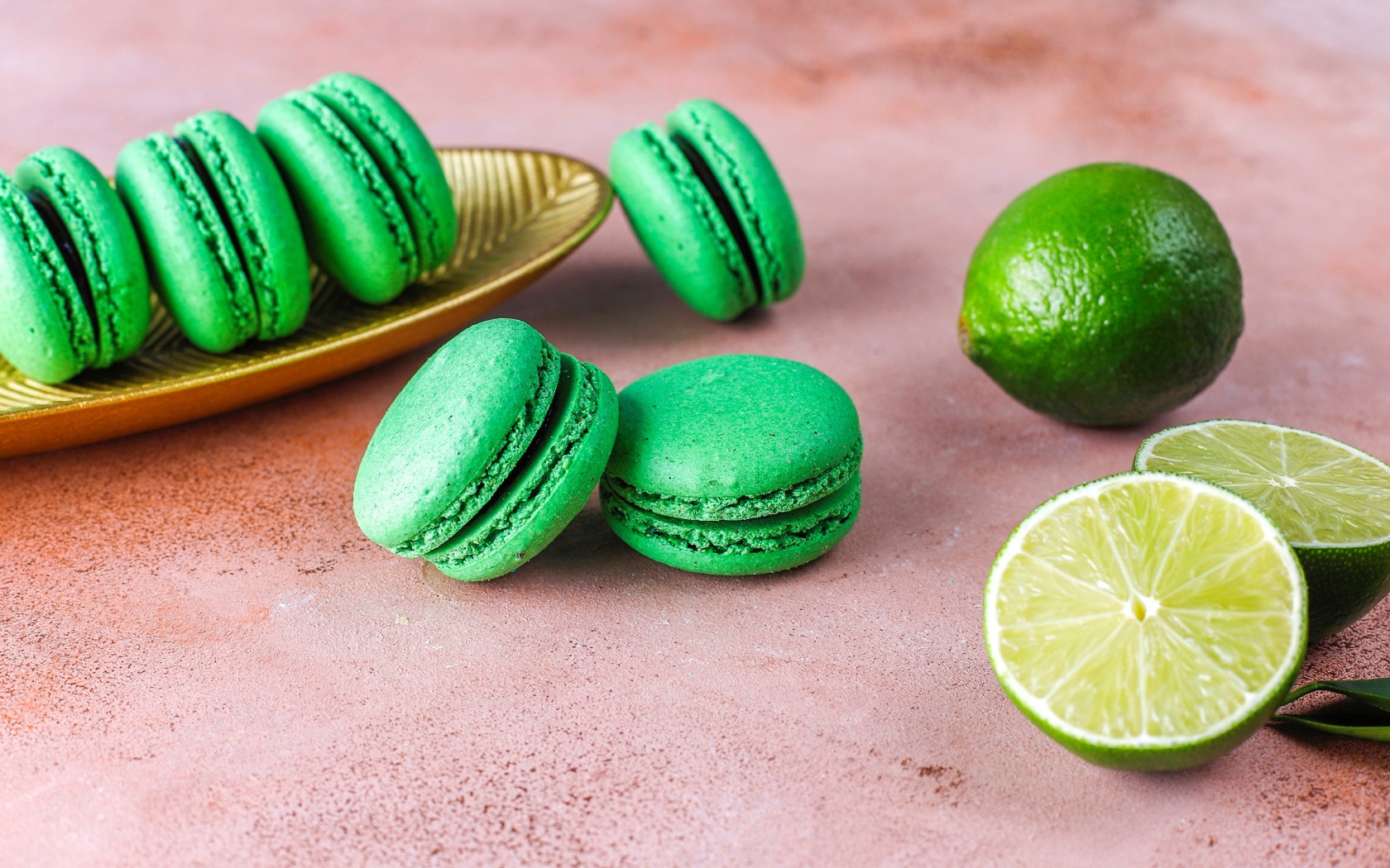 Зеленый десерт макарун на столе с лаймом