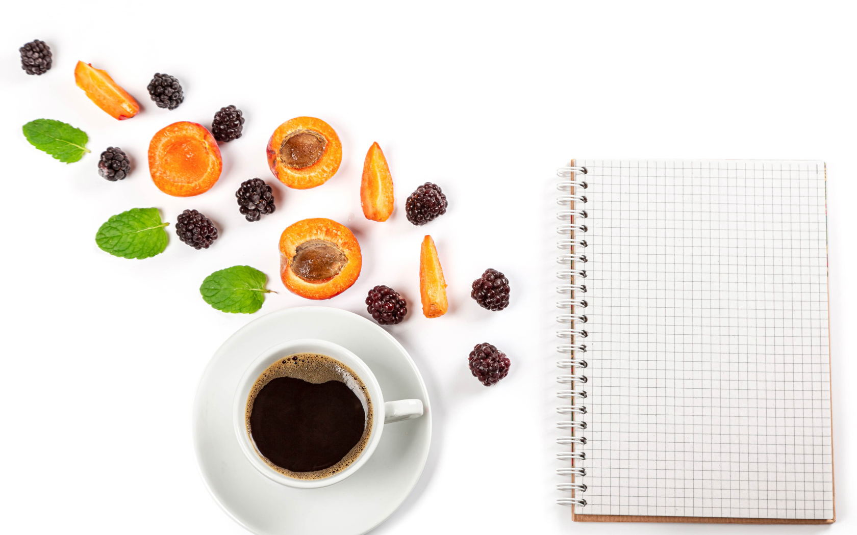 Чашка кофе, тетрадь, черника и абрикос на белом фоне