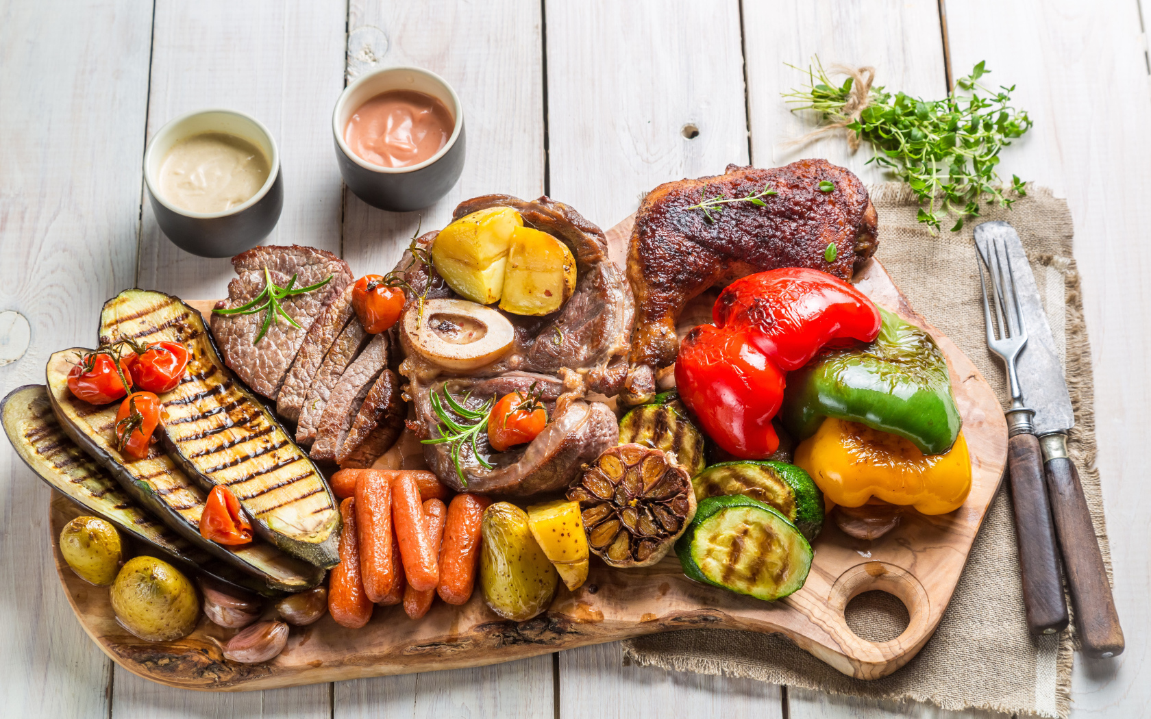 Pieces of baked meat on a board with vegetables