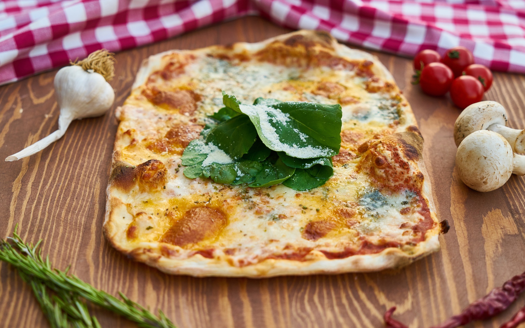 Румяная пицца на столе с овощами