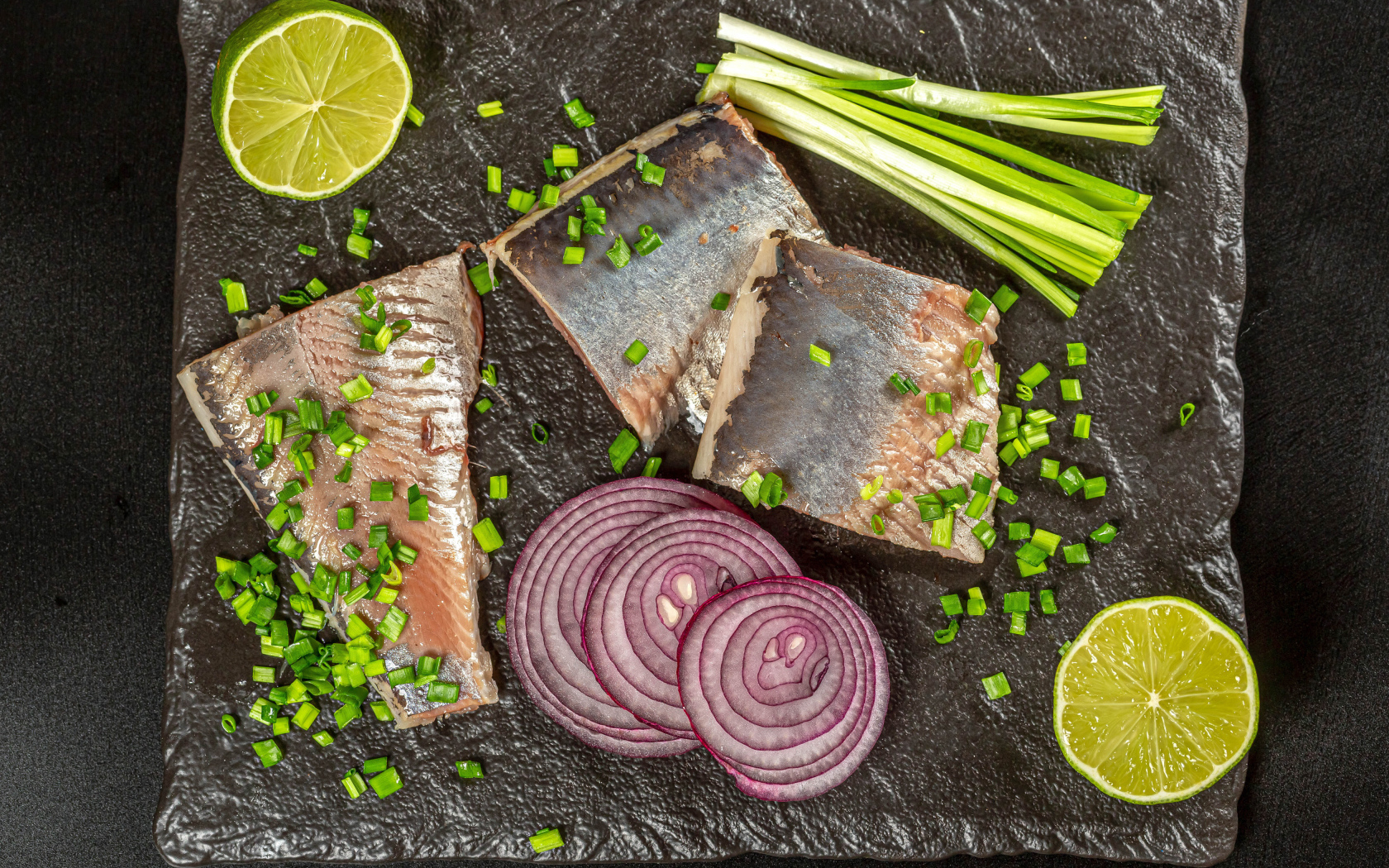 Куски сельди с луком и кусочками лимона