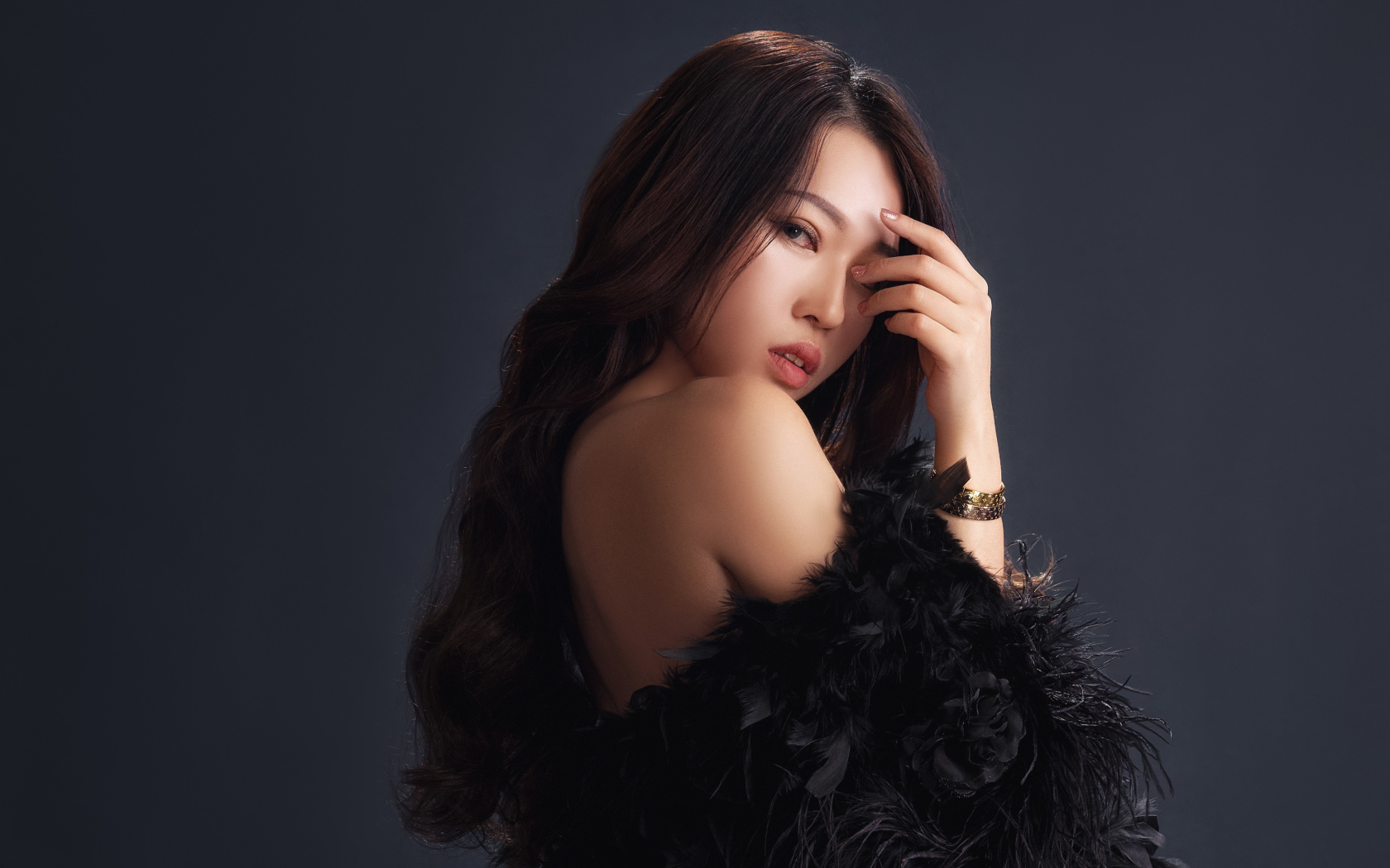 Красивая девушка в черном манто на сером фоне