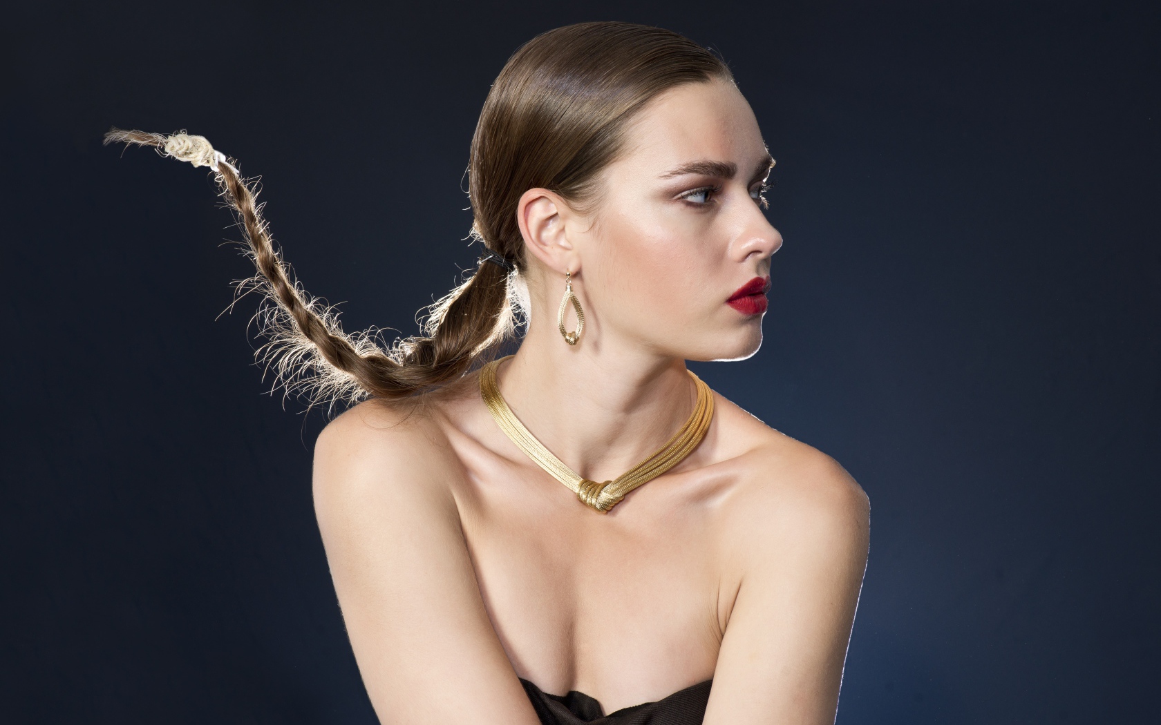 Красивая девушка с косой на голове на сером фоне