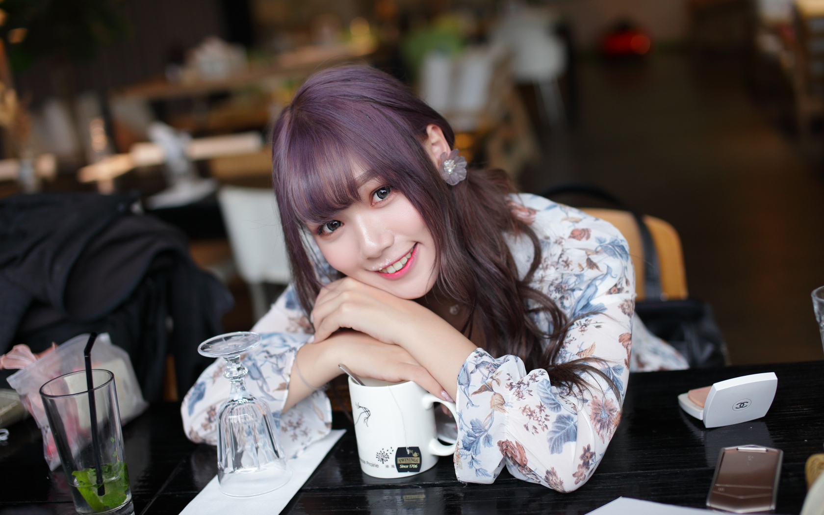 Милая девушка азиатка сидит за столиком