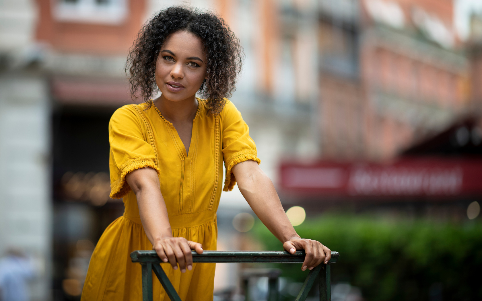 Девушка с кудрявым волосами в желтом платье