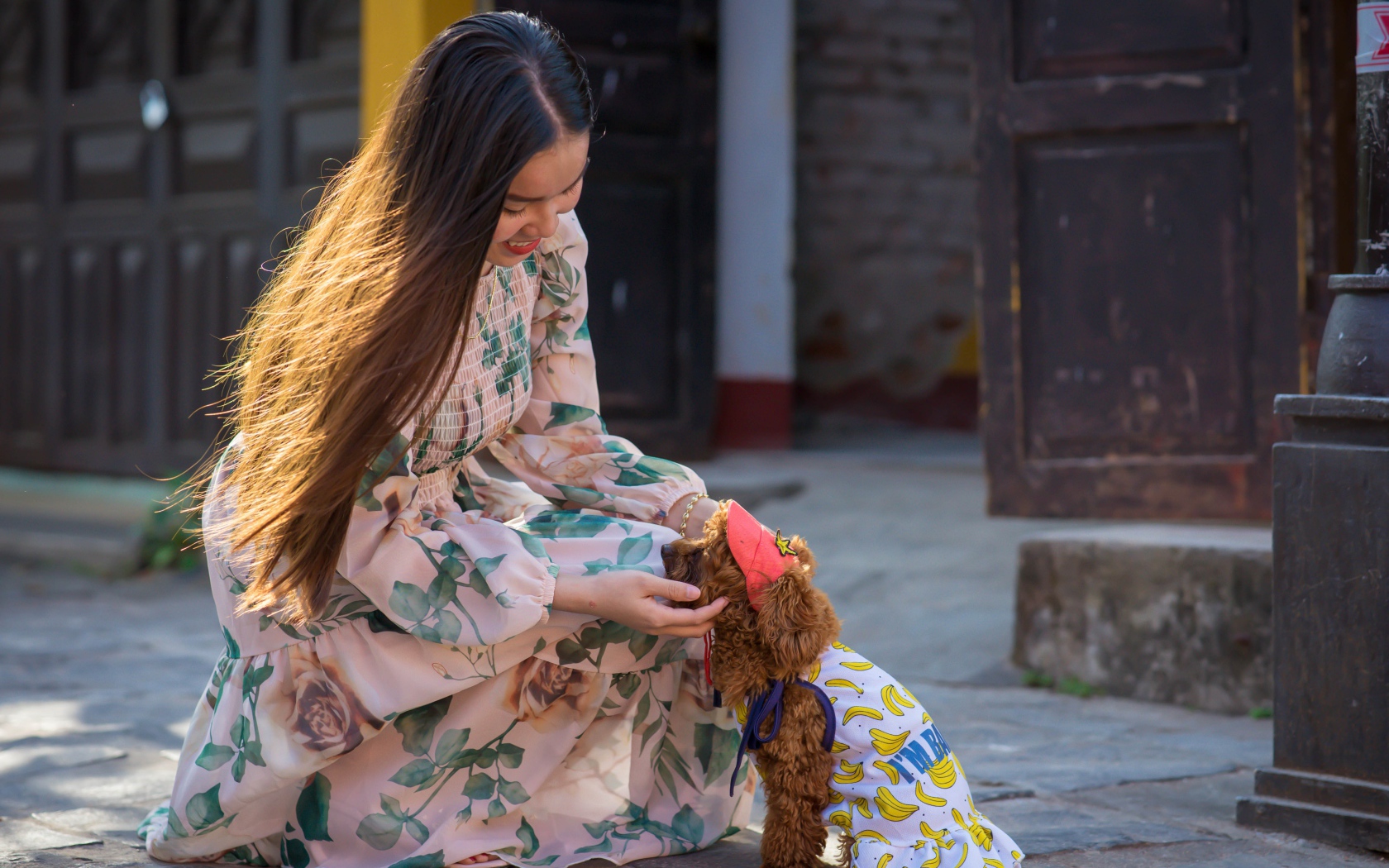 Улыбающаяся девушка азиатка с собакой 