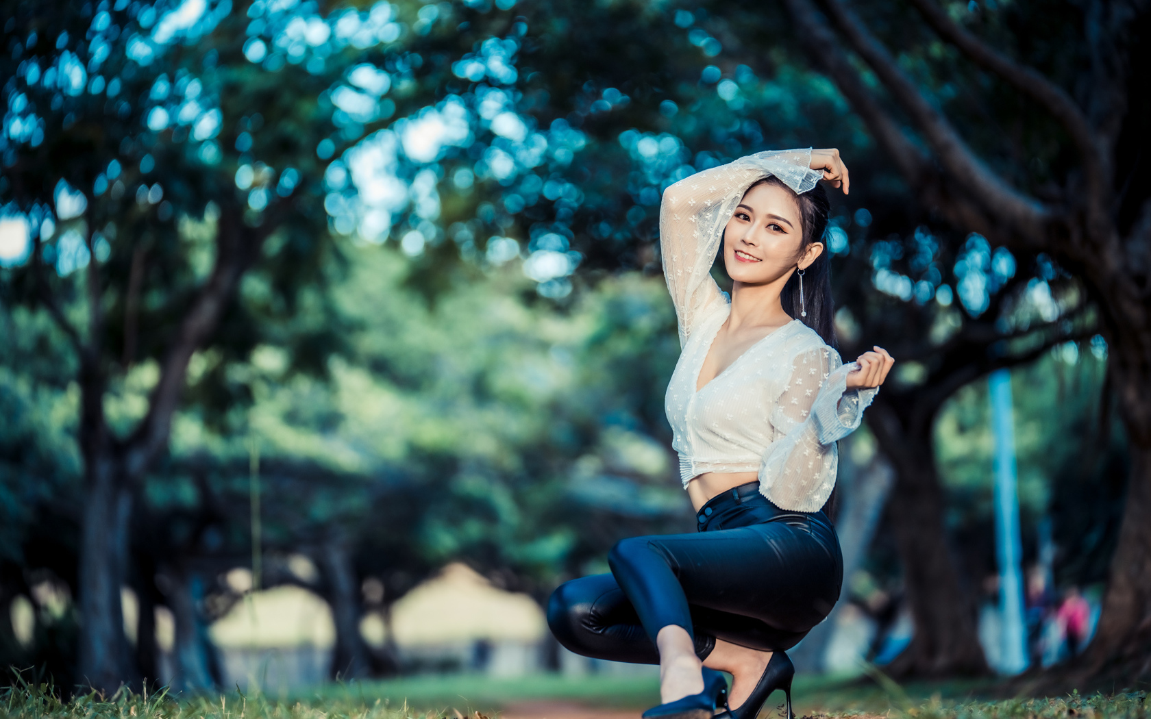 Улыбающаяся азиатка в черных брюках