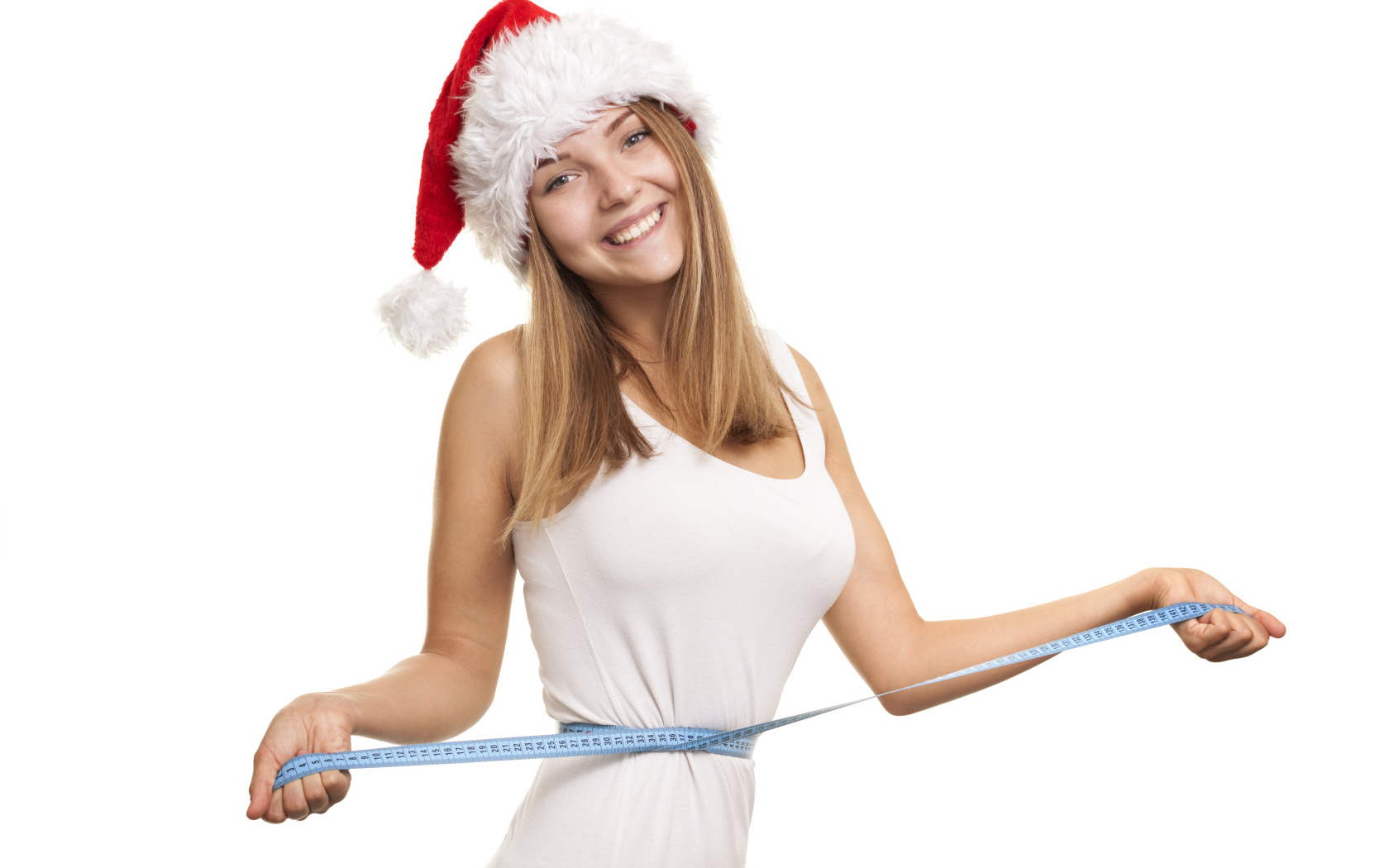 Стройная девушка в новогодней шапке на белом фоне