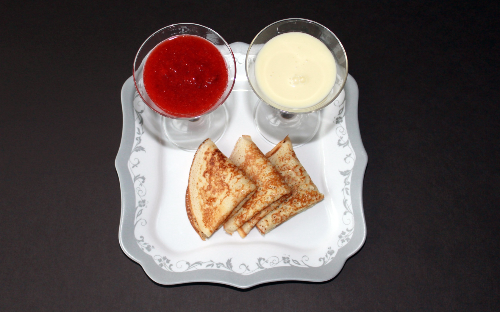 Блинчики с вареньем и сметаной на столе на Масленицу