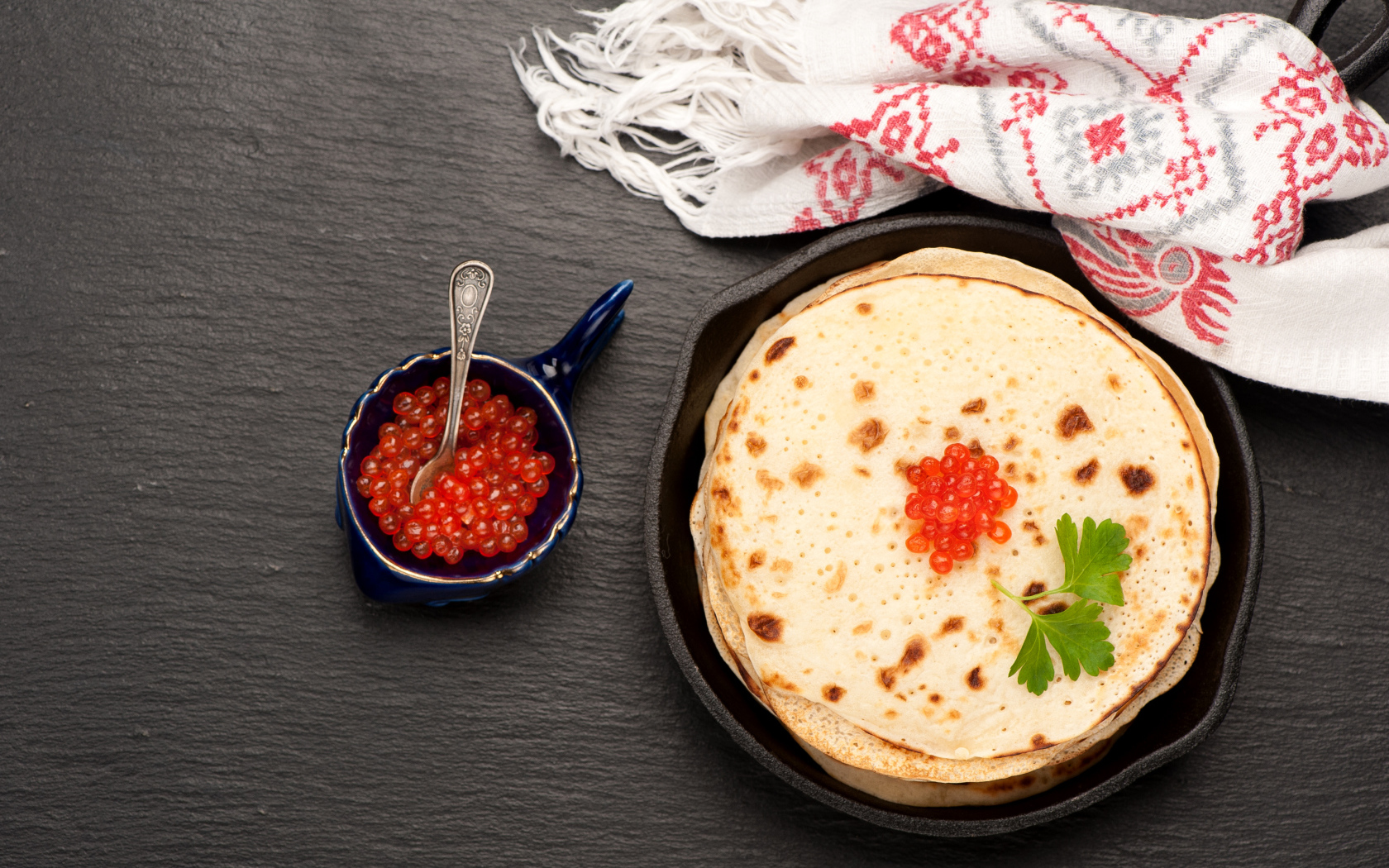 Тонкие блинчики с красной икрой на столе