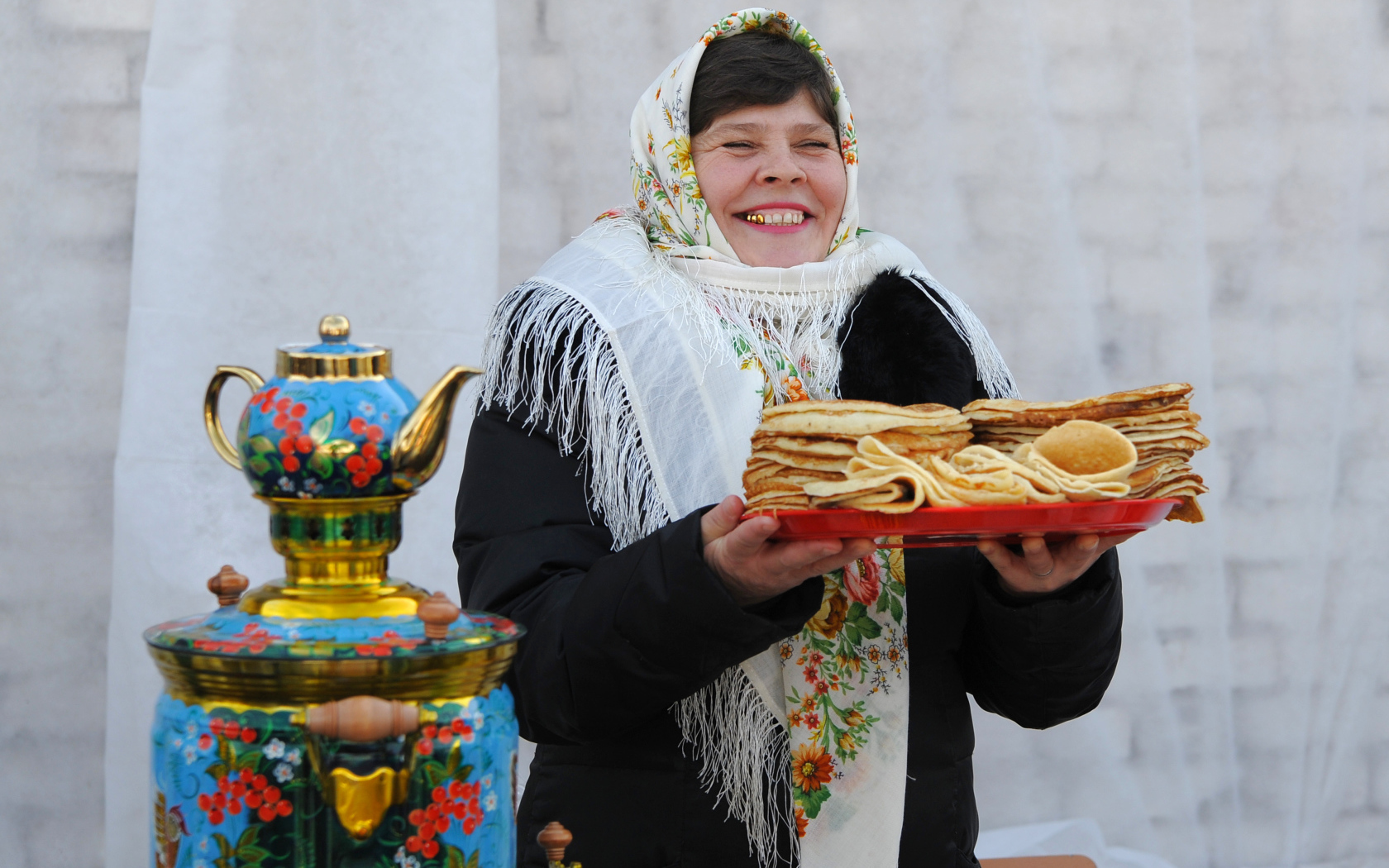 Женщина с блинами и самоваром на Масленицу