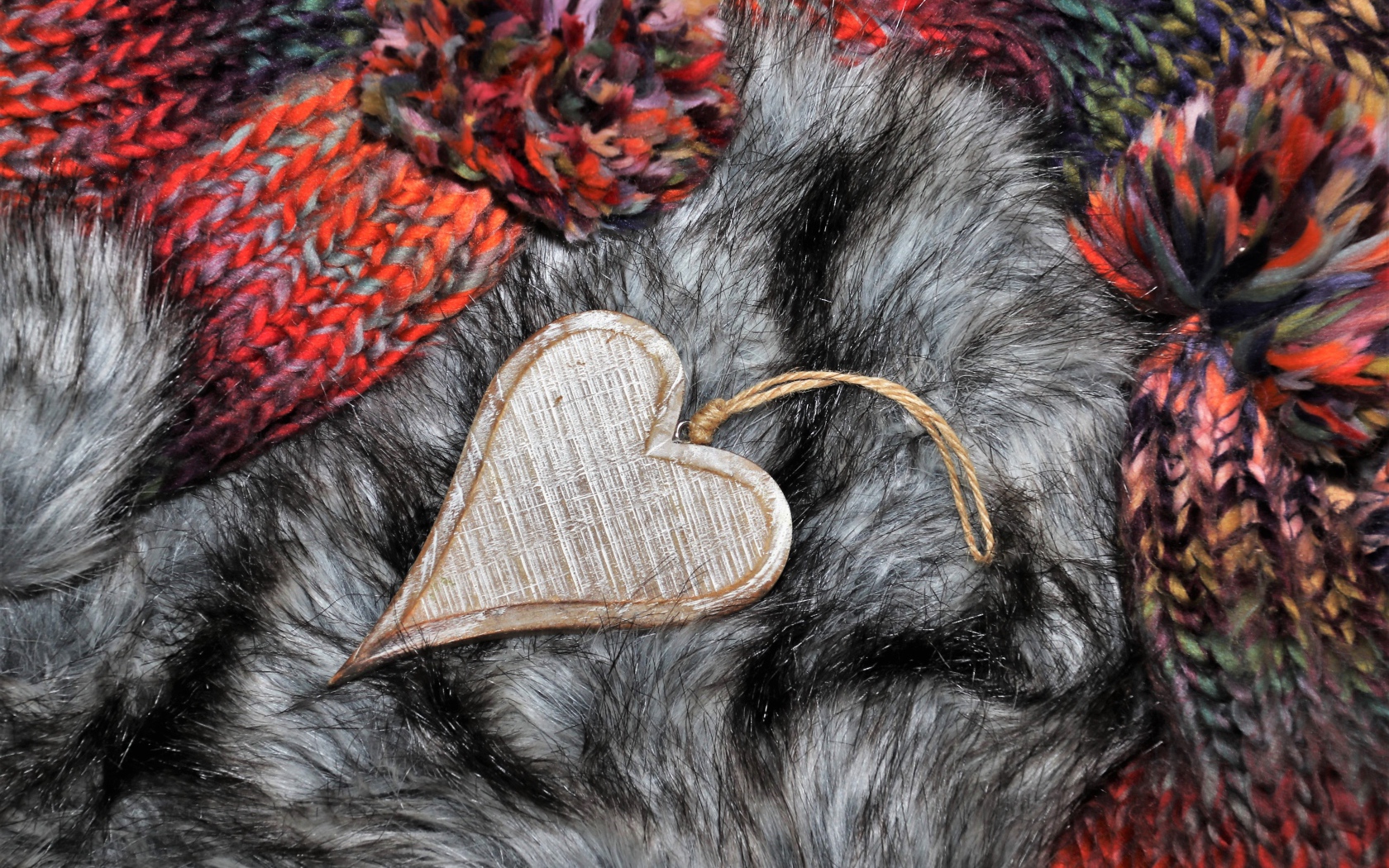 Wooden heart lies on a fur hat