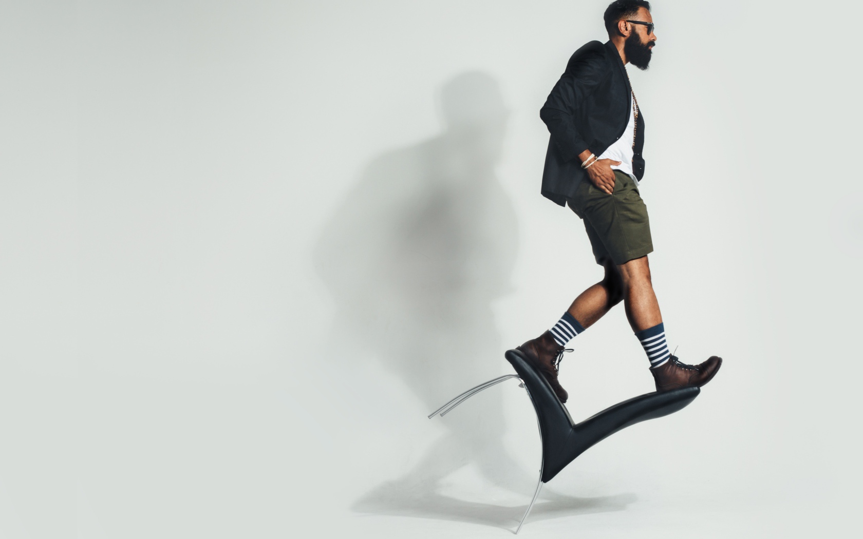 Мужчина балансирует на черном кресле