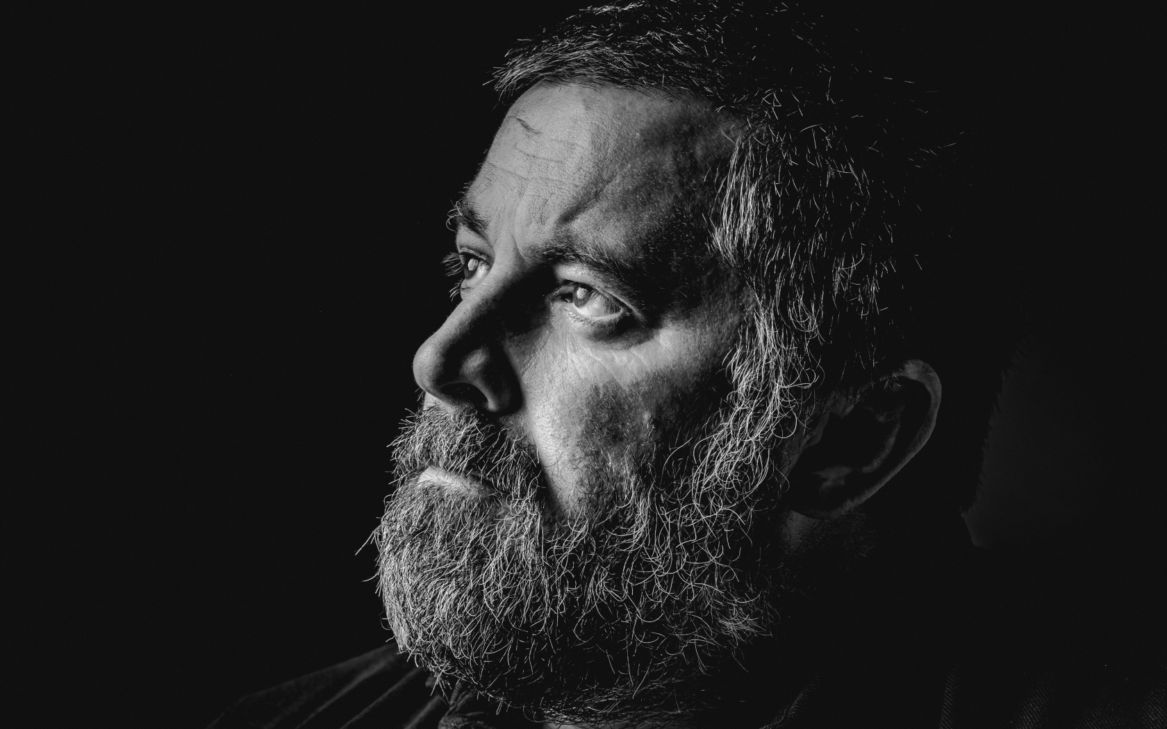 Мужчина с седой бородой на черном фоне 