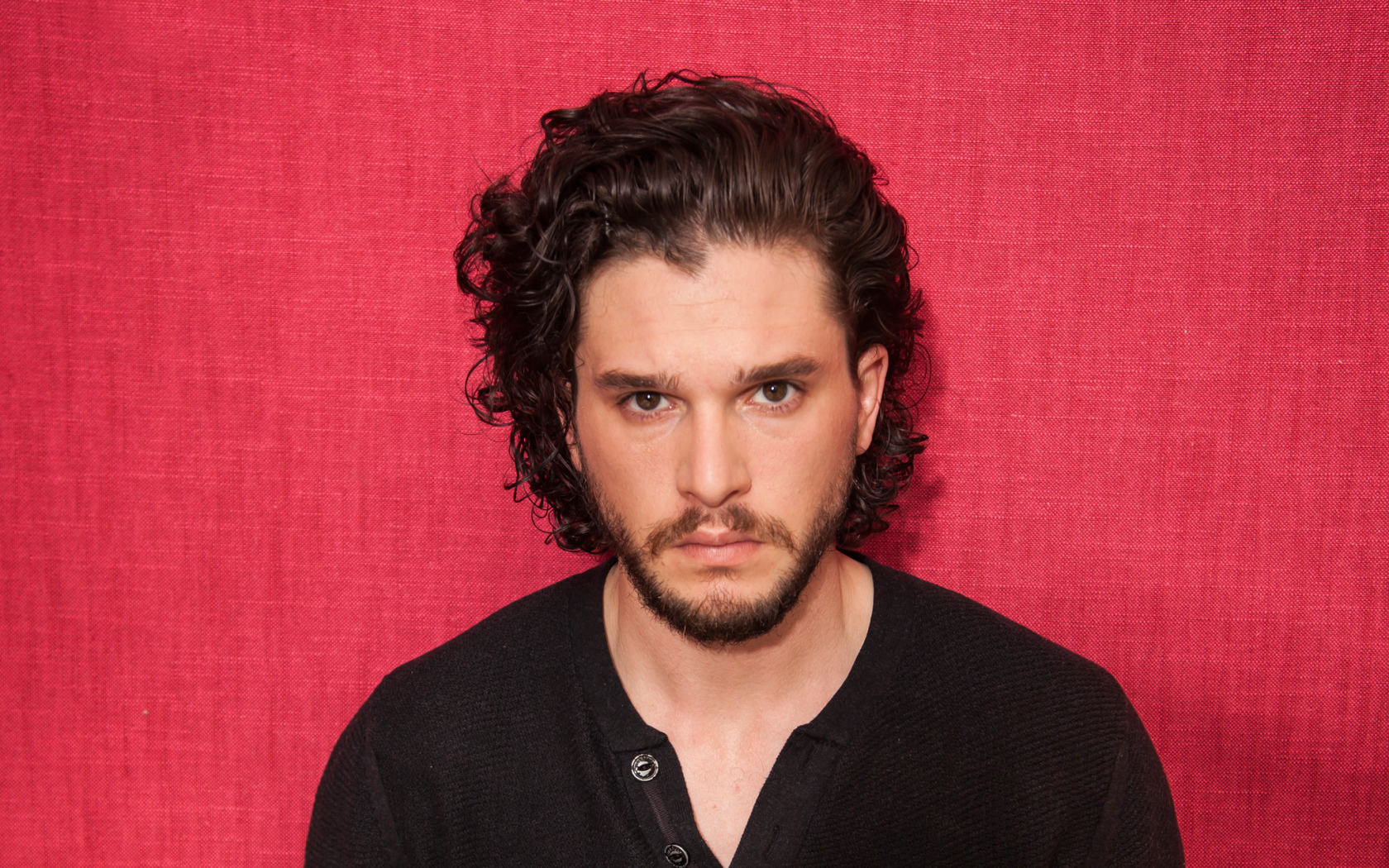 Актер  Кит Харингтон на розовом фоне