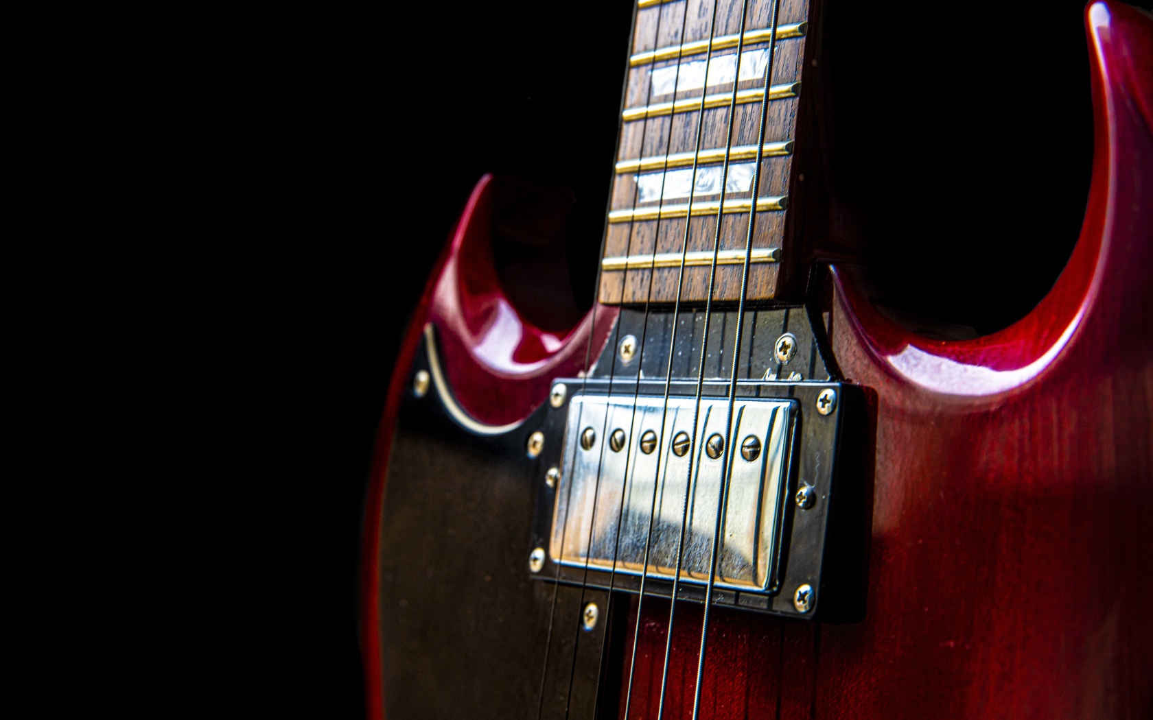 Красная гитара со струнами на черном фоне 
