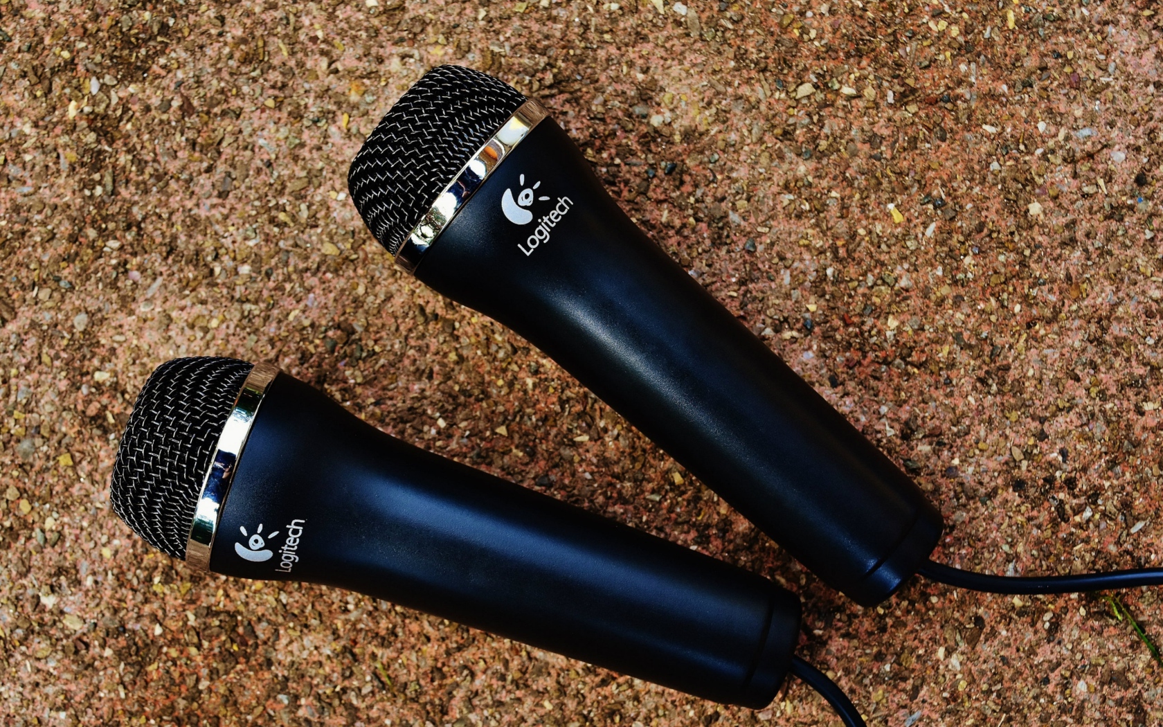 Two Logitech microphones on the pavement