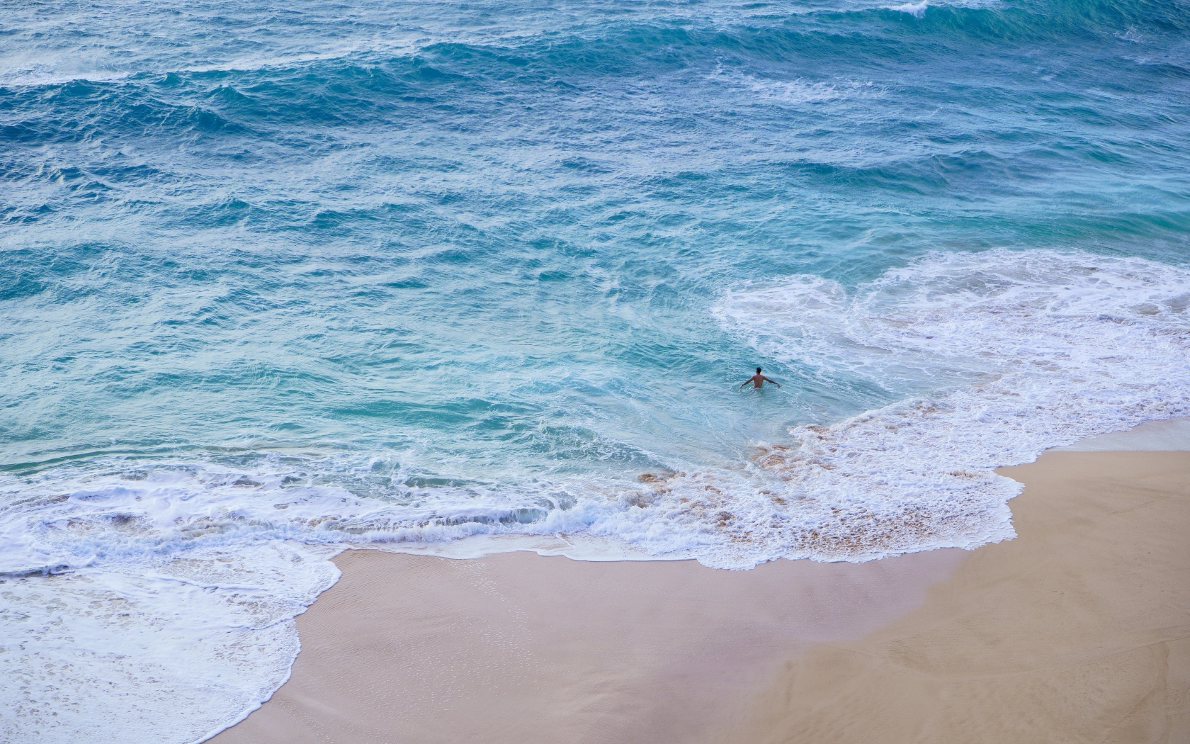 Чистый пляж с белыми морскими волнами на песке