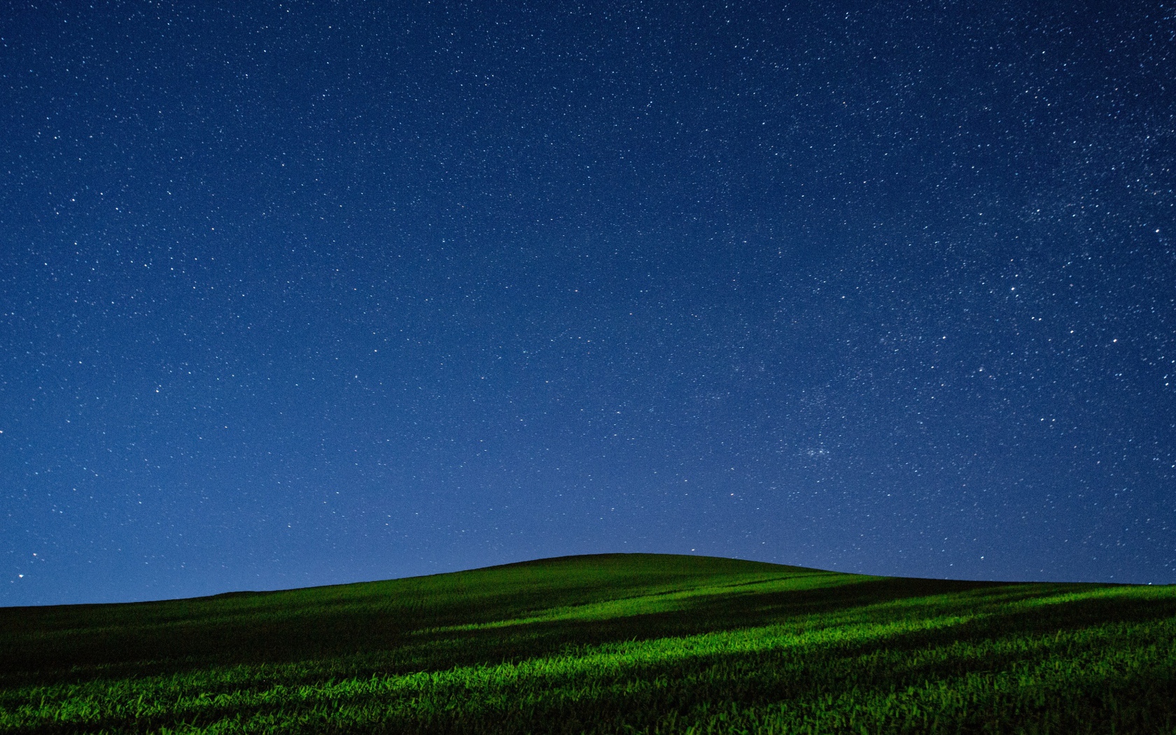 Красивое звездное ночное небо над зеленым полем