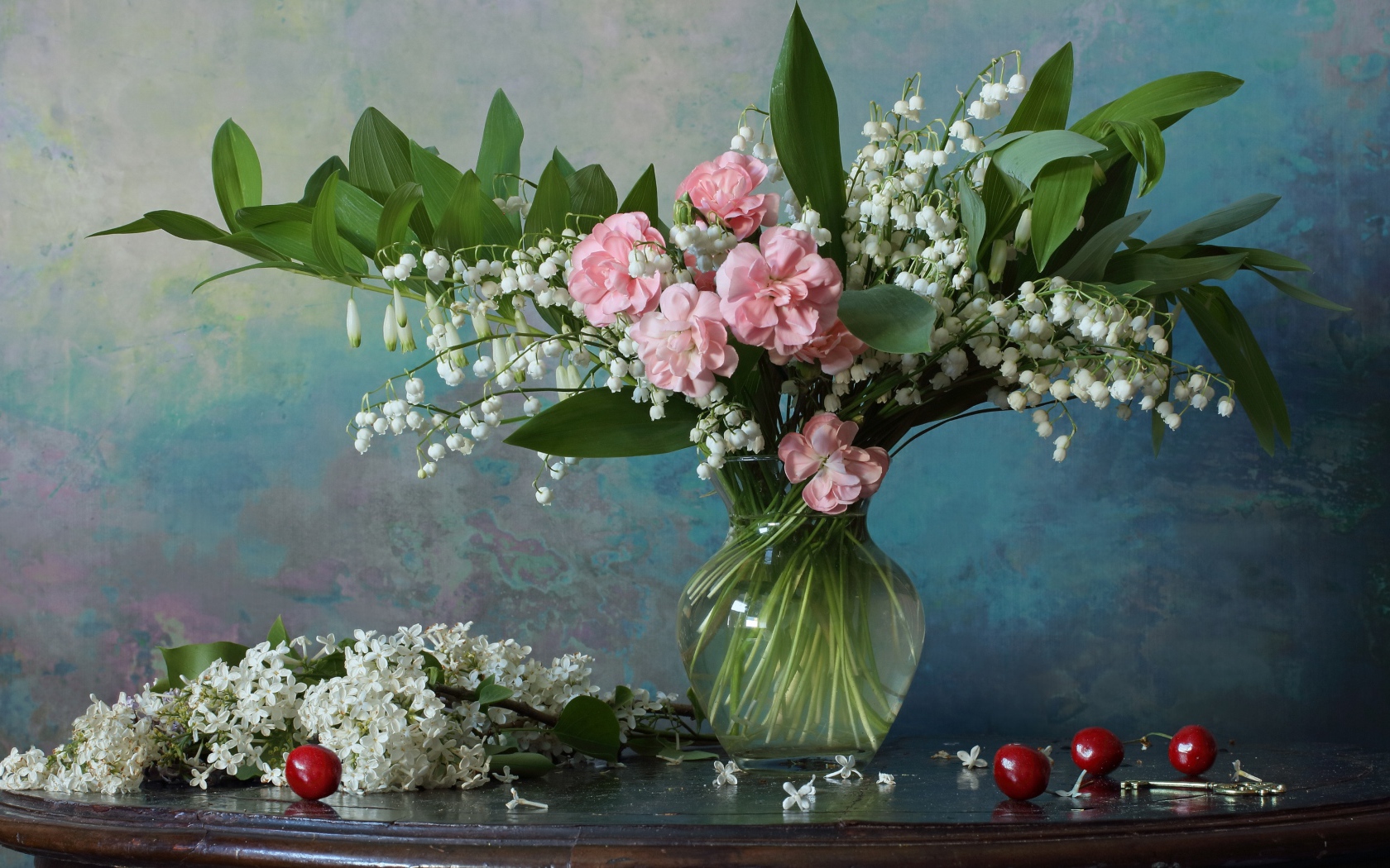 Красивый букет ландышей с розовыми цветами на столе с веткой сирени 