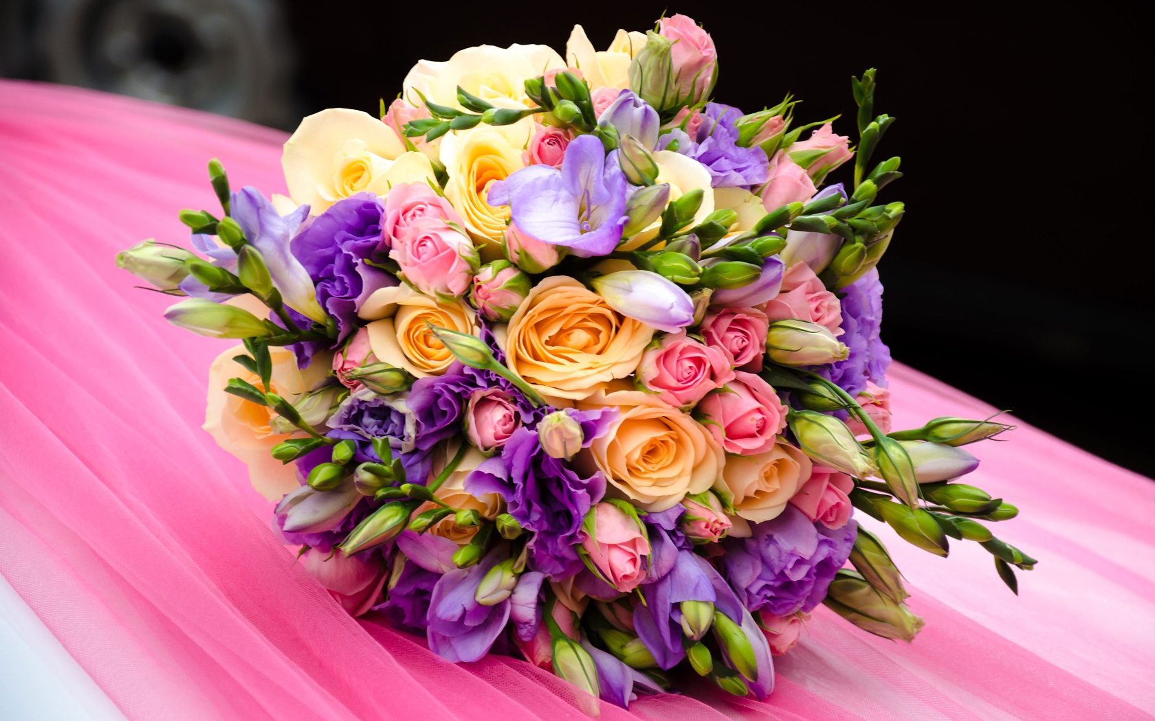 Красивый свадебный букет лежит на розовой ткани