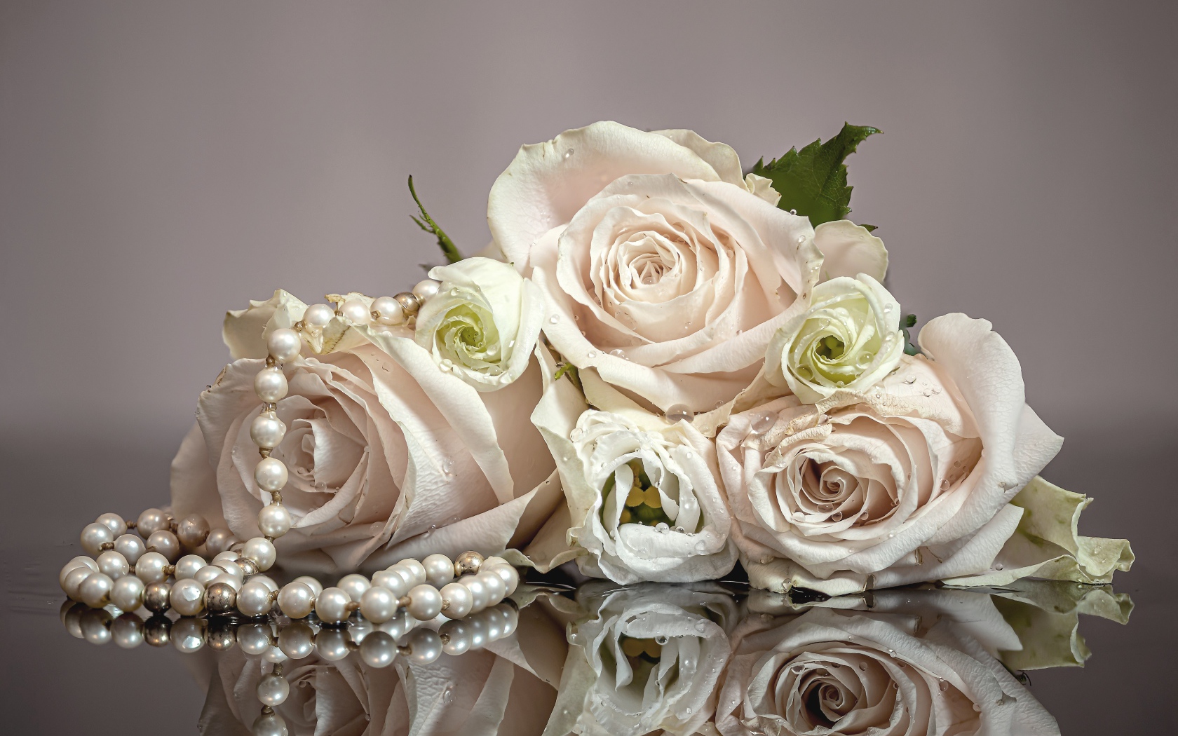 Букет белых роз с бусами на сером фоне