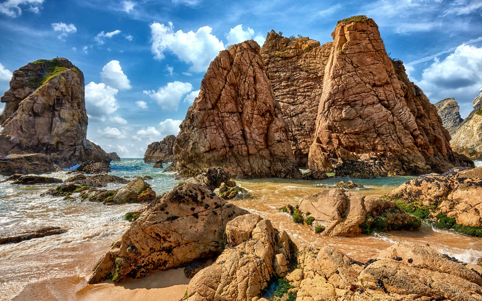 Большие каменные возвышенности в море под голубым небом 