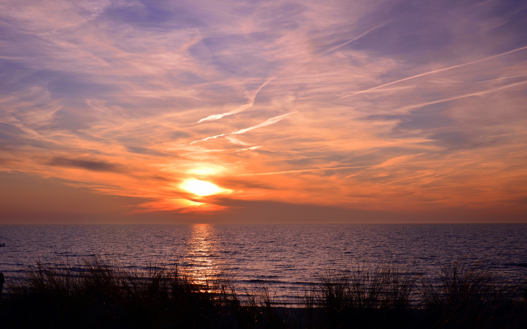 Закат солнца над спокойным озером летом