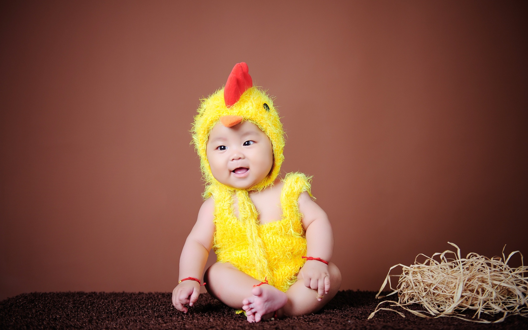 Маленький мальчик азиат в костюме цыпленка