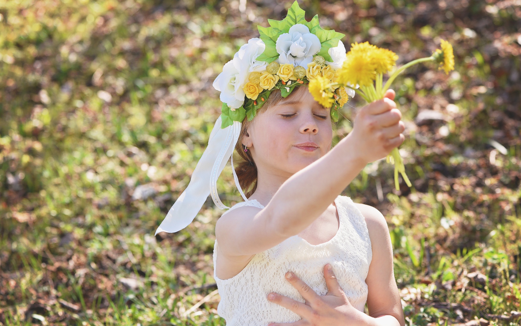 Маленькая девочка с букетом одуванчиках в руке 