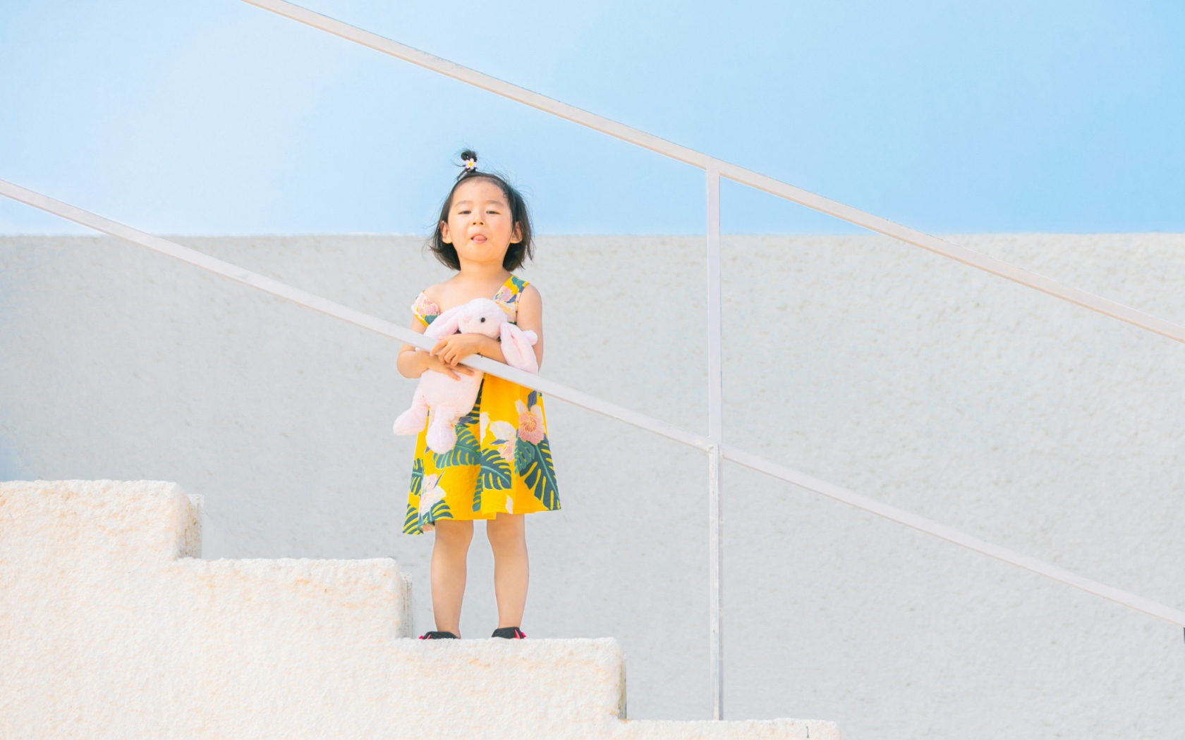 Маленькая девочка с игрушкой на ступеньках 