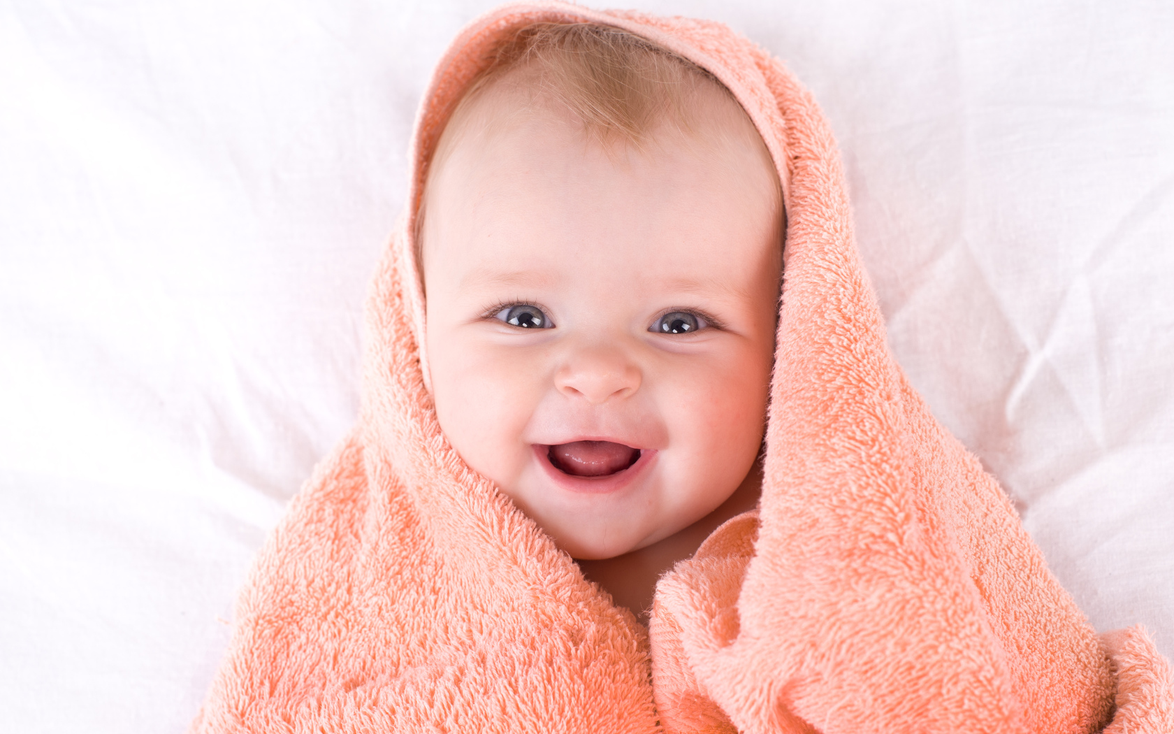 Улыбающийся грудной ребенок в полотенце