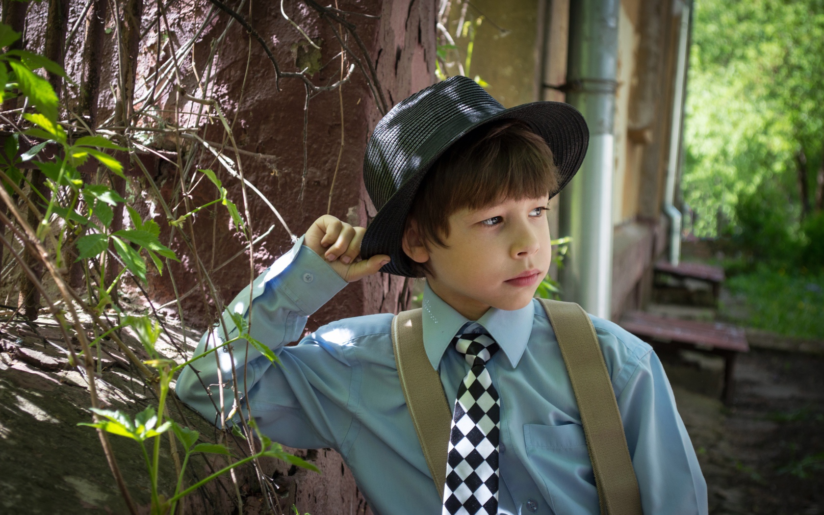 Стильный мальчик в черной шляпе 