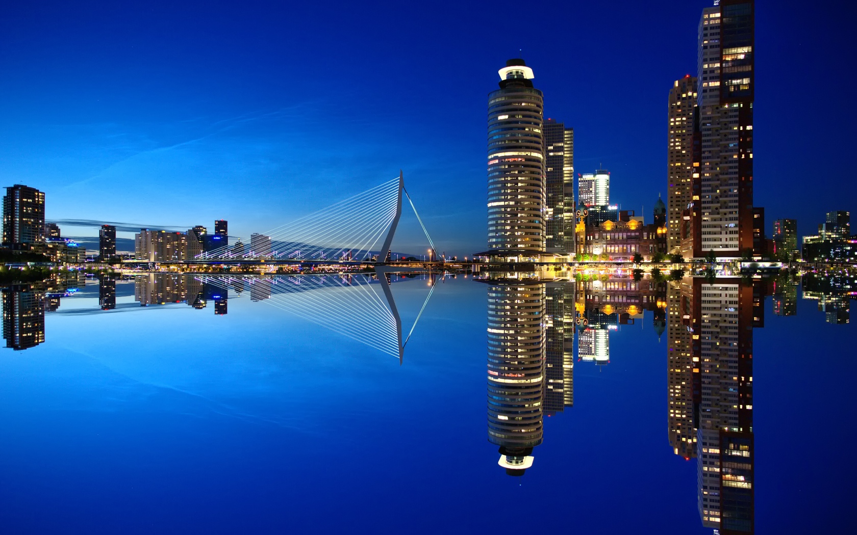 Небоскребы и мост отражаются в тихой воде