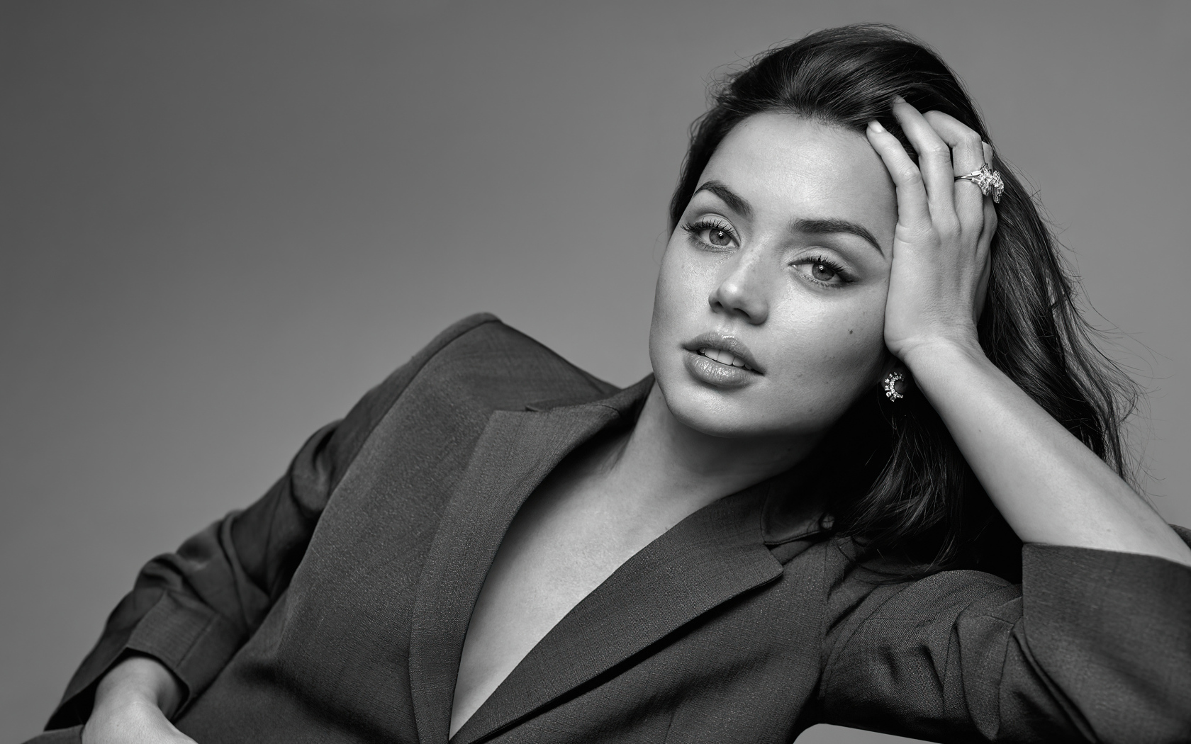 Актриса Ана де Армас в пиджаке на сером фоне