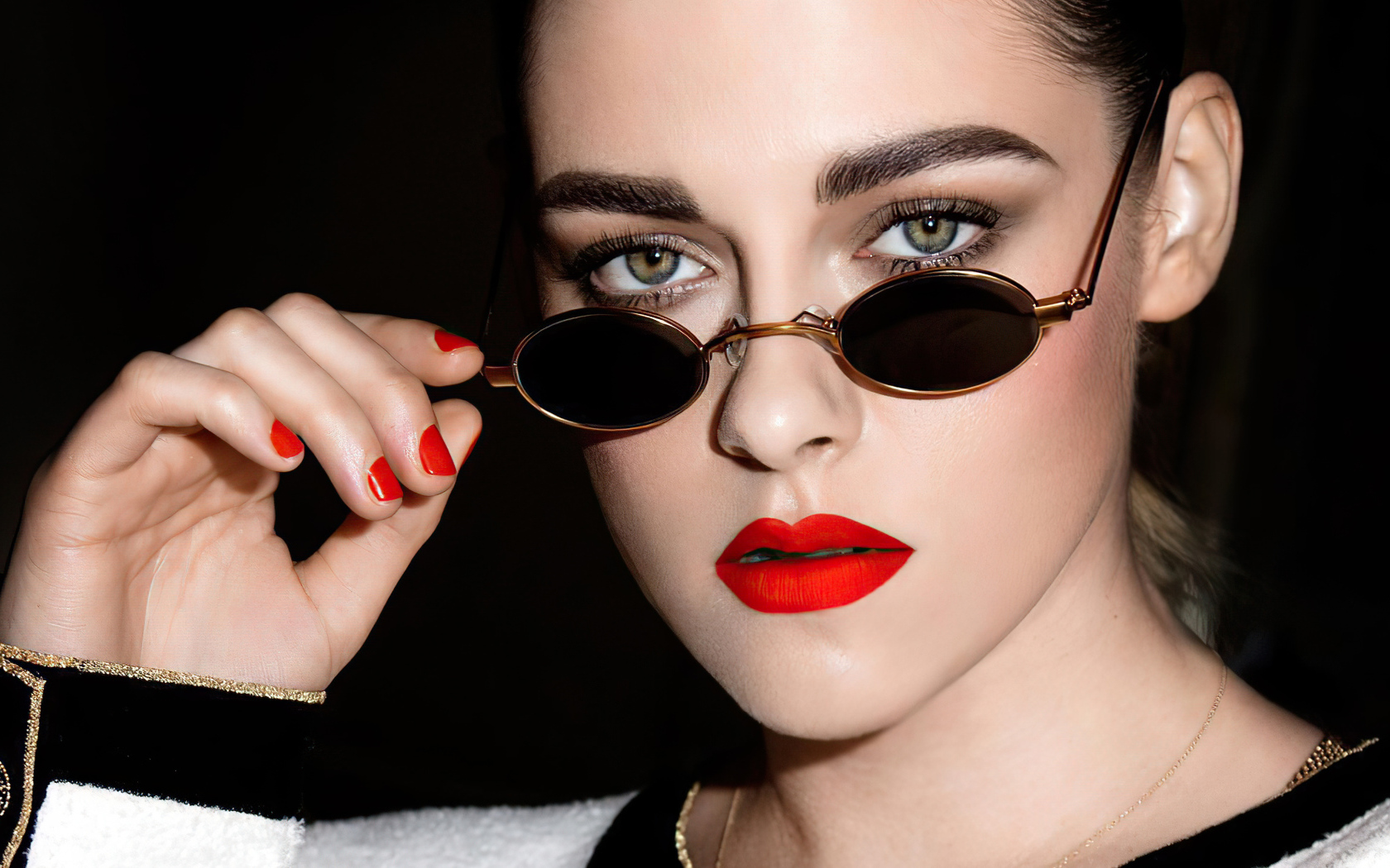 Актриса Кристен Стюарт в очках на  черном фоне