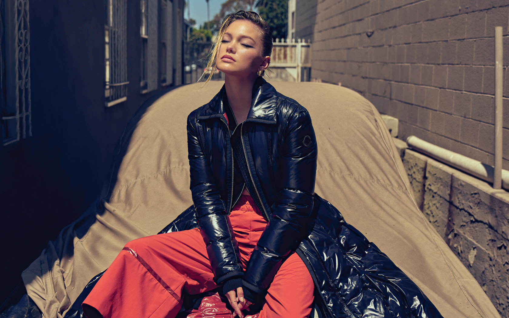 Актриса Оливия Холт в черной куртке сидит на машине