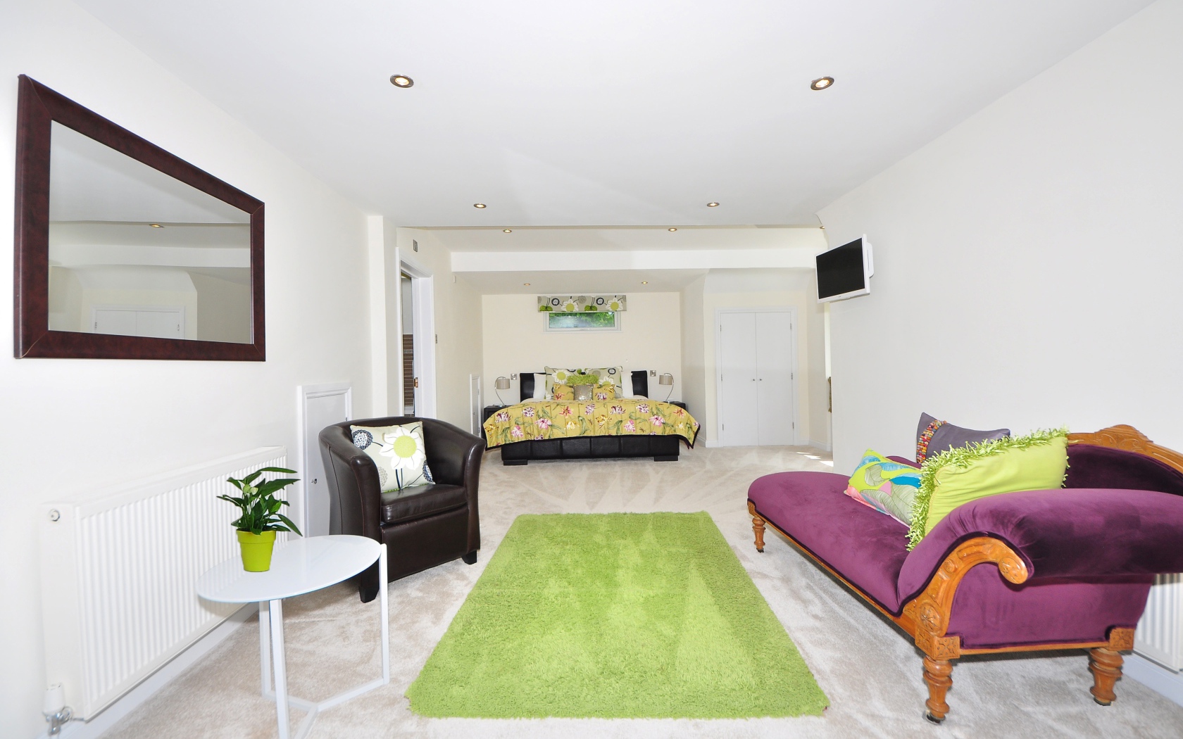 Большая гостиная с высокими белыми стенами и мебелью 