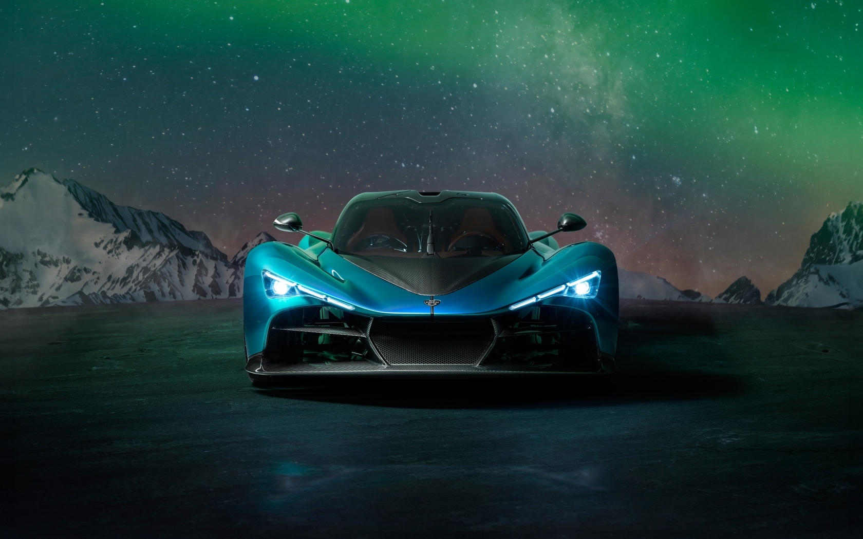 Голубой спортивный автомобиль Zenvo Aurora на фоне гор и полярного сияния