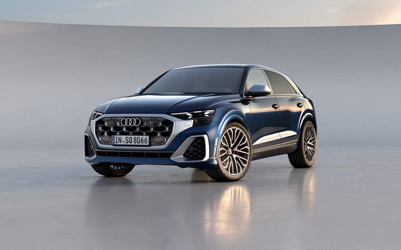 Синий автомобиль Audi SQ8 TFSI 2023 года на сером фоне