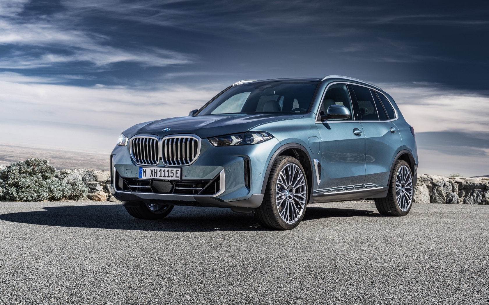 Автомобиль BMW X5 2023 на фоне грозового неба