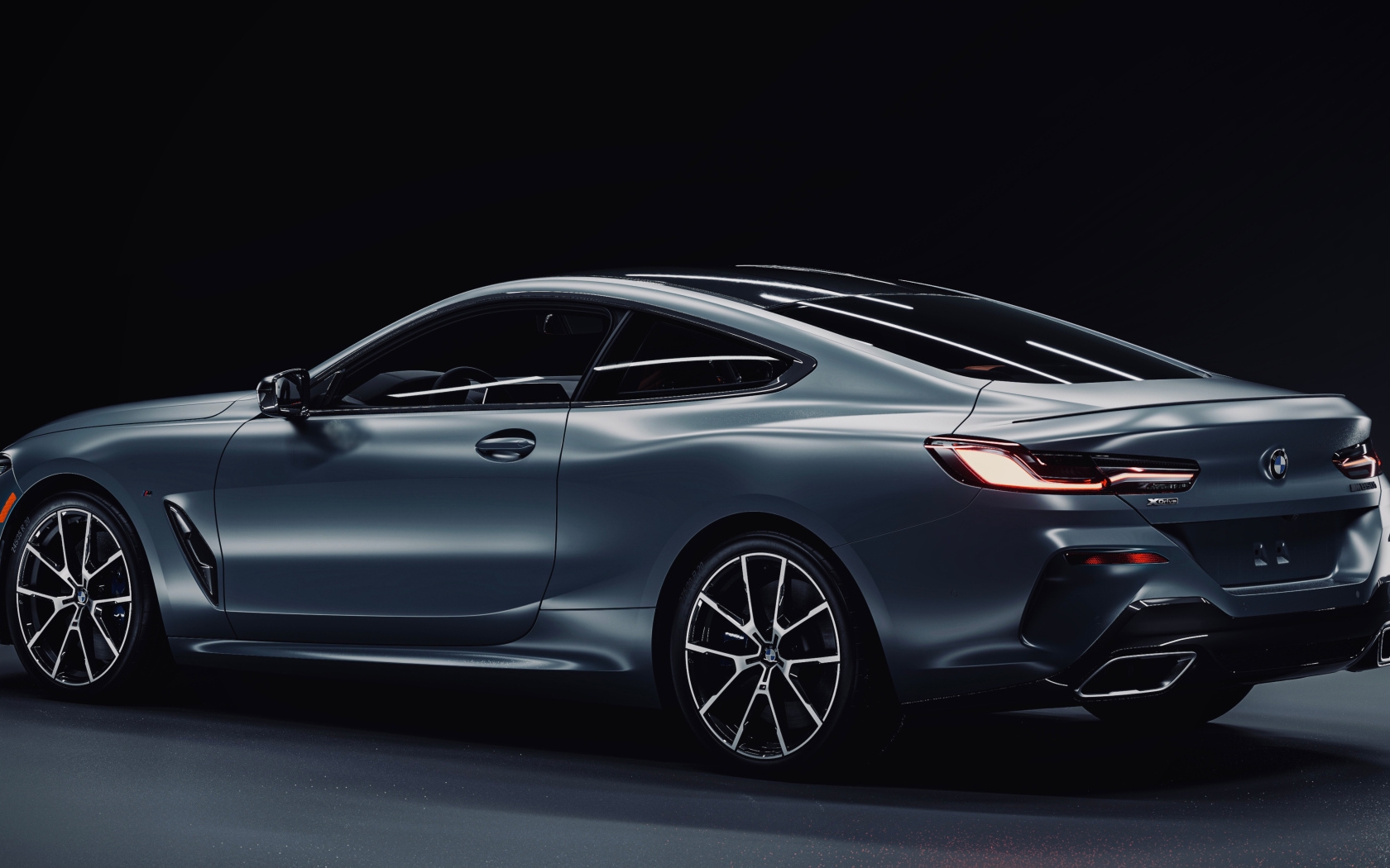 Дорогой серебристый автомобиль BMW M850i CGI  вид сзади