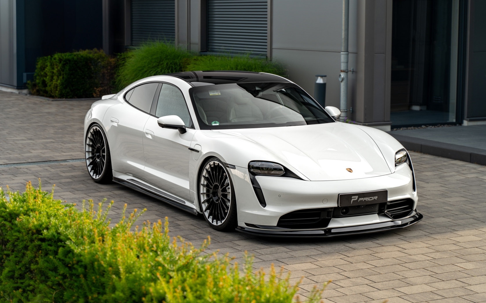 Автомобиль Porsche Taycan у здания