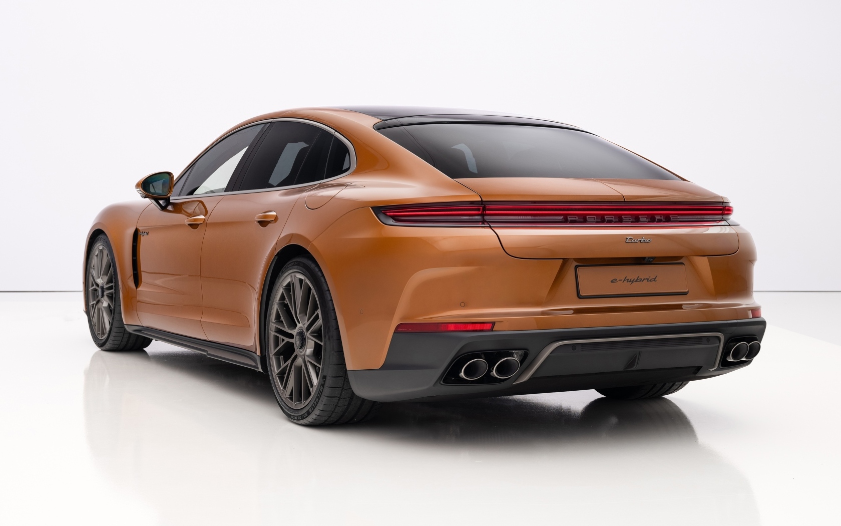 Вид сзади на автомобиль Porsche Panamera Turbo E-Hybrid 2024 года