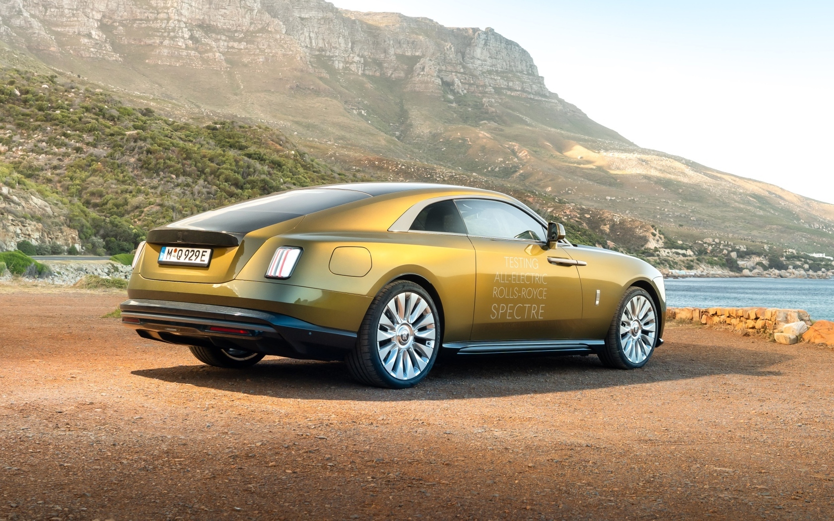 Золотистый Rolls-Royce Spectre вид сзади